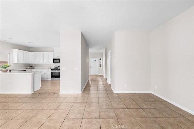 43453 Tali St, Lancaster, CA 93535 - kitchen featuring gas stove, light countertops, light tile patterned floors, white cabinetry, and baseboards