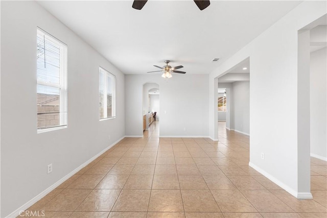 40729 Oakmont Ct, Palmdale, CA 93551 - empty room featuring a ceiling fan, arched walkways, light tile patterned flooring, and baseboards