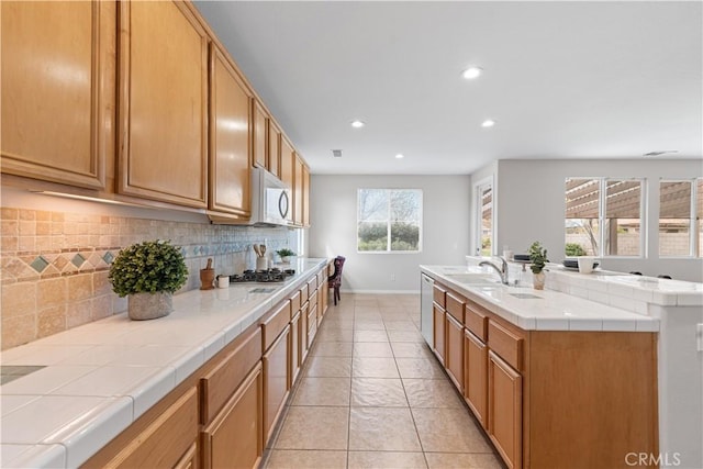 40729 Oakmont Ct, Palmdale, CA 93551 - kitchen with decorative backsplash, baseboards, recessed lighting, white microwave, and tile counters