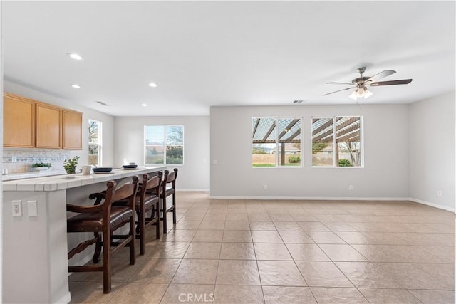 40729 Oakmont Ct, Palmdale, CA 93551 - kitchen with tile countertops, light tile patterned floors, recessed lighting, baseboards, and ceiling fan