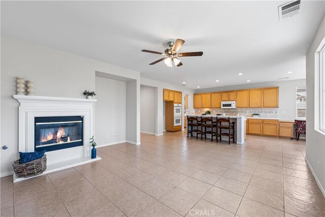 40729 Oakmont Ct, Palmdale, CA 93551 - living room featuring light tile patterned floors, ceiling fan, baseboards, recessed lighting, and a glass covered fireplace