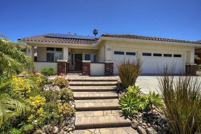 5110 Wisteria Dr, Oceanside, CA 92056 - view of front of property featuring an attached garage, solar panels, and stucco siding