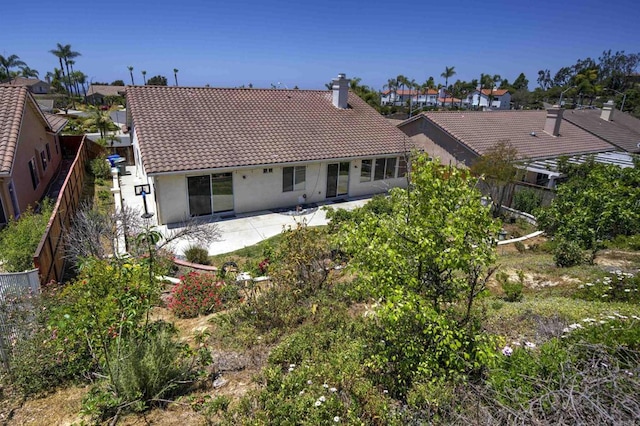5110 Wisteria Dr, Oceanside, CA 92056 - rear view of house with a chimney, a tile roof, stucco siding, a patio, and a residential view