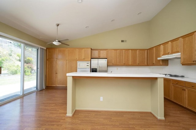 5110 Wisteria Dr, Oceanside, CA 92056 - kitchen featuring stainless steel fridge with ice dispenser, under cabinet range hood, tasteful backsplash, ceiling fan, and light wood-style flooring