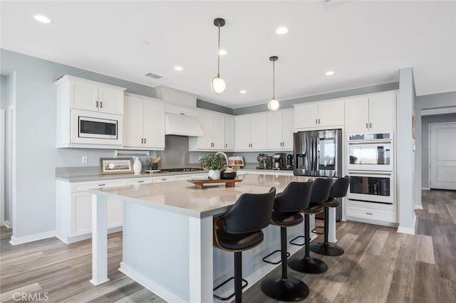 18171 Hedgerow Way, Saugus, CA 91350 - kitchen featuring stainless steel appliances, premium range hood, a kitchen island, light countertops, and white cabinets