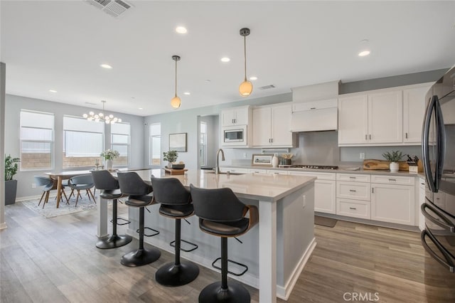 18171 Hedgerow Way, Saugus, CA 91350 - kitchen with built in microwave, premium range hood, white cabinetry, and recessed lighting