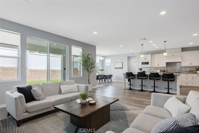 18171 Hedgerow Way, Saugus, CA 91350 - living room with light wood finished floors, a chandelier, and recessed lighting