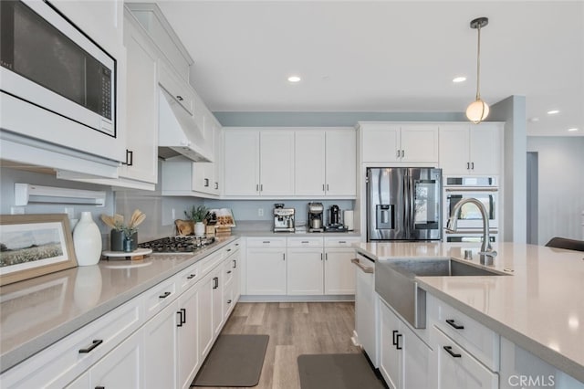 18171 Hedgerow Way, Saugus, CA 91350 - kitchen featuring appliances with stainless steel finishes, white cabinetry, light countertops, decorative light fixtures, and recessed lighting