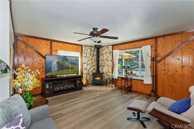 22771 Fir Ln, Crestline, CA 92325 - living area with wood walls, a wood stove, ceiling fan, and wood finished floors