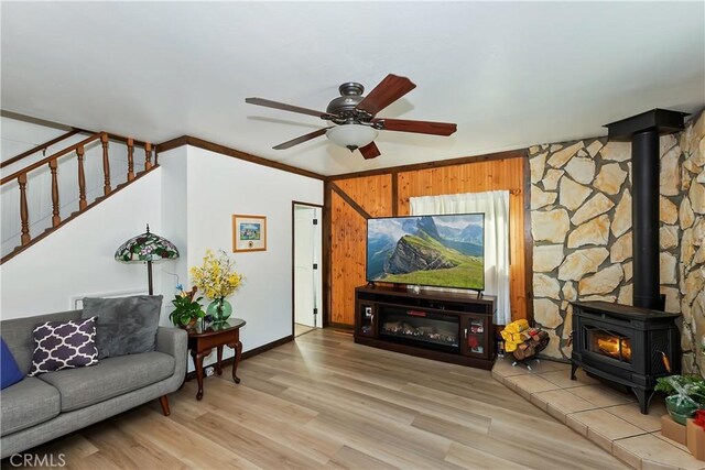 22771 Fir Ln, Crestline, CA 92325 - living room featuring a wood stove, a ceiling fan, wood finished floors, and stairs