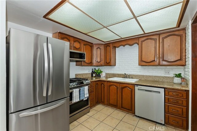 22771 Fir Ln, Crestline, CA 92325 - kitchen featuring stainless steel appliances, a sink, brown cabinets, and light tile patterned floors