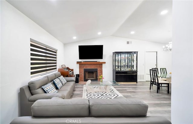 7035 Jon Allan Dr, North Hollywood, CA 91605 - living room with lofted ceiling, wood finished floors, a chandelier, a brick fireplace, and recessed lighting