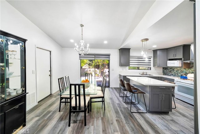 7035 Jon Allan Dr, North Hollywood, CA 91605 - dining area featuring vaulted ceiling, a chandelier, wood finished floors, and recessed lighting