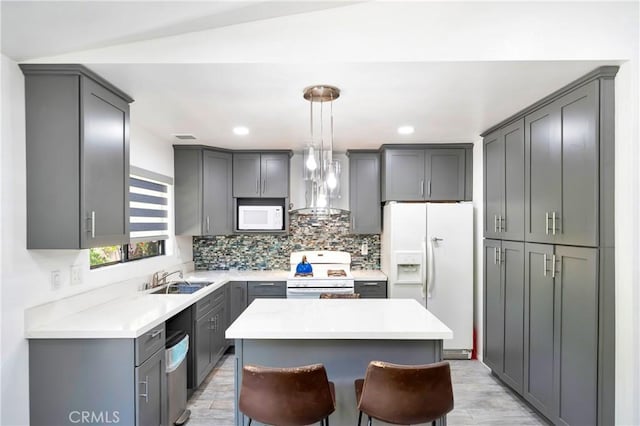 7035 Jon Allan Dr, North Hollywood, CA 91605 - kitchen featuring white appliances, wall chimney range hood, a sink, tasteful backsplash, and gray cabinets