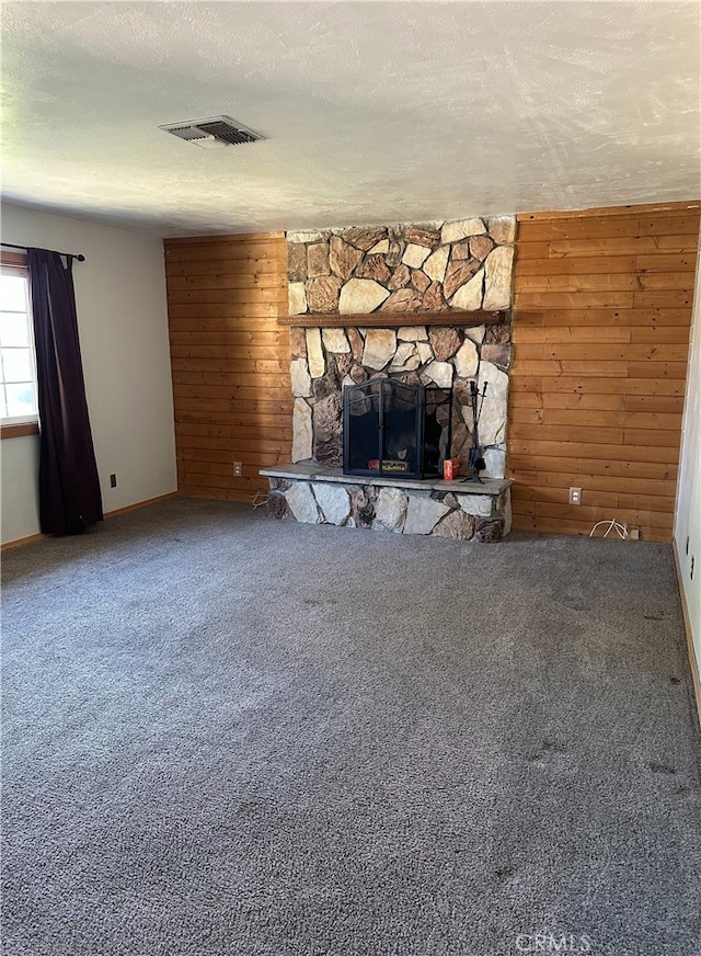 2378 Thisa Way, Hemet, CA 92544 - unfurnished living room with wood walls, carpet, a textured ceiling, a stone fireplace, and baseboards