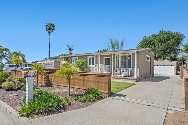 1529 Moreno St, Oceanside, CA 92054 - view of front facade featuring covered porch, a fenced front yard, a garage, an outbuilding, and stucco siding