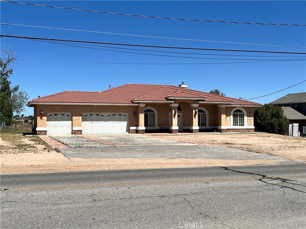 17322 Danbury Ave, Hesperia, CA 92345 - mediterranean / spanish-style home featuring stucco siding, a garage, and a tile roof