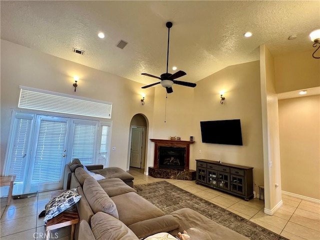 17322 Danbury Ave, Hesperia, CA 92345 - tiled living area featuring a textured ceiling, arched walkways, lofted ceiling, ceiling fan, and baseboards