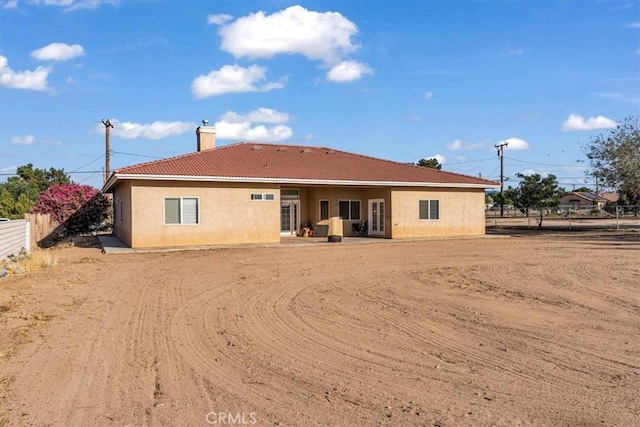 17322 Danbury Ave, Hesperia, CA 92345 - back of house featuring a tiled roof, a chimney, and stucco siding