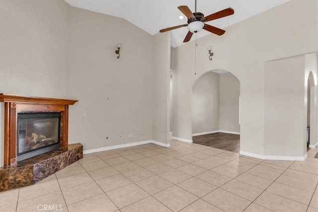 17322 Danbury Ave, Hesperia, CA 92345 - unfurnished living room with arched walkways, vaulted ceiling, ceiling fan, light tile patterned floors, and a glass covered fireplace