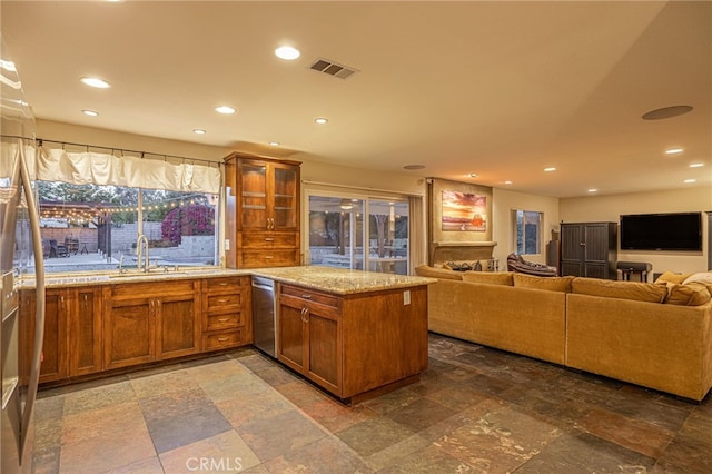 28367 Mount Stephen Ave, Canyon Country, CA 91387 - kitchen with brown cabinetry, stone tile floors, light stone counters, open floor plan, and a peninsula