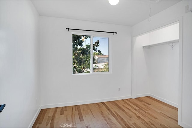 3031 4th Ave, Los Angeles, CA 90018 - unfurnished bedroom with light wood-style floors, attic access, and baseboards