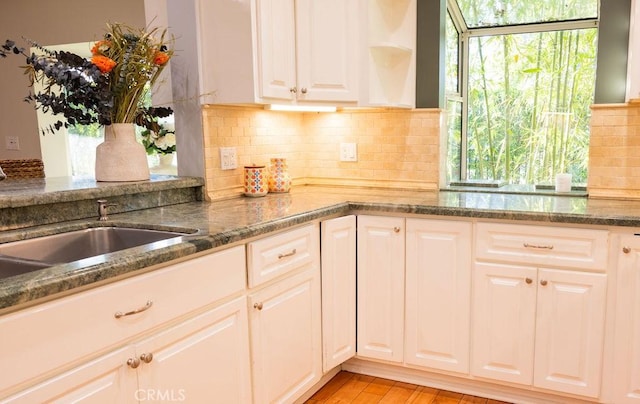14816 Covello St, Van Nuys, CA 91405 - kitchen with open shelves, white cabinetry, dark stone countertops, and decorative backsplash