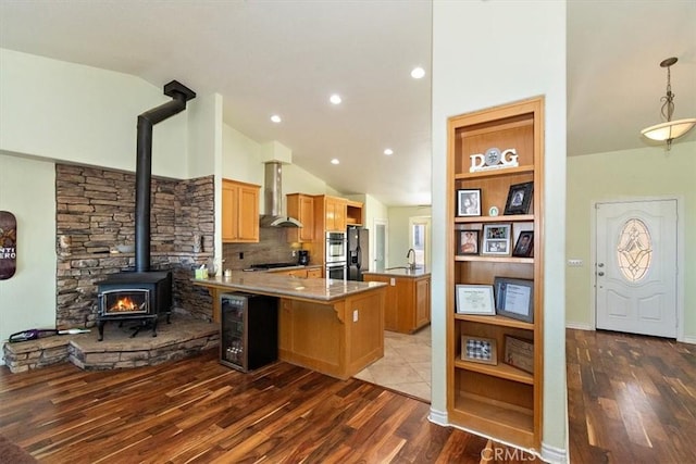 9050 Ponderosa Rd, Pinon Hills, CA 92372 - kitchen featuring wall chimney exhaust hood, a peninsula, a wood stove, double oven, and beverage cooler