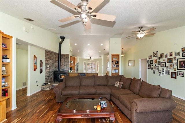 9050 Ponderosa Rd, Pinon Hills, CA 92372 - living room featuring a ceiling fan, wood finished floors, a wood stove, a textured ceiling, and baseboards
