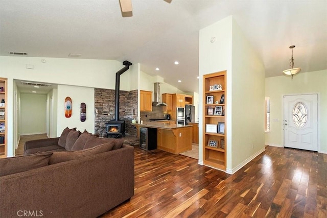 9050 Ponderosa Rd, Pinon Hills, CA 92372 - living room featuring a wood stove, lofted ceiling, dark wood-type flooring, a ceiling fan, and baseboards