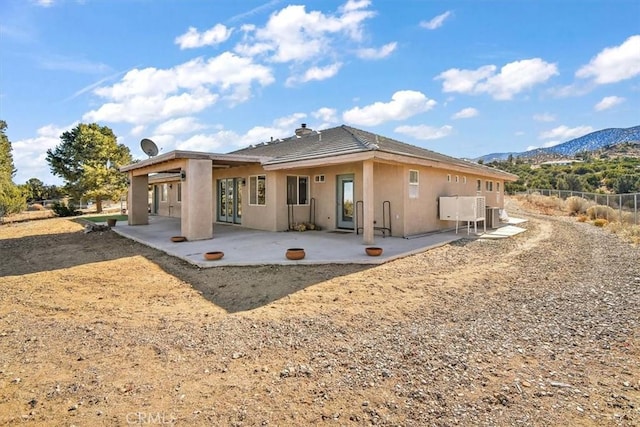 9050 Ponderosa Rd, Pinon Hills, CA 92372 - back of house featuring a mountain view, a patio area, and stucco siding