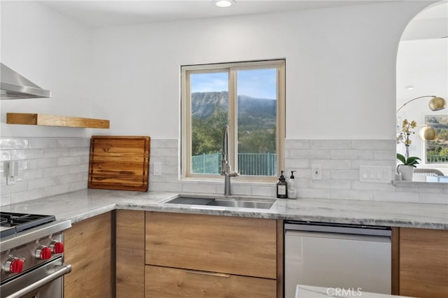 44310 Calle Bernardo, Temecula, CA 92590 - kitchen featuring a sink, stainless steel appliances, tasteful backsplash, light stone counters, and wall chimney range hood