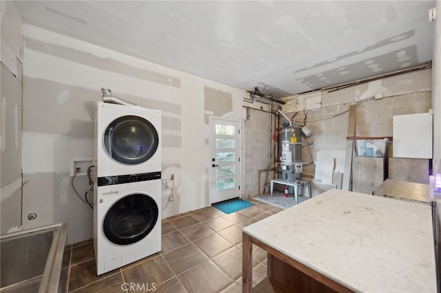 44310 Calle Bernardo, Temecula, CA 92590 - laundry area with stacked washer and clothes dryer, secured water heater, and a barn door