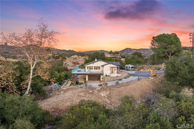 44310 Calle Bernardo, Temecula, CA 92590 - back of property with an attached garage, a mountain view, stairway, dirt driveway, and a chimney