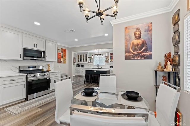 1422 S Exmoor Ave, Compton, CA 90220 - dining room featuring a chandelier, ornamental molding, wood finished floors, and recessed lighting