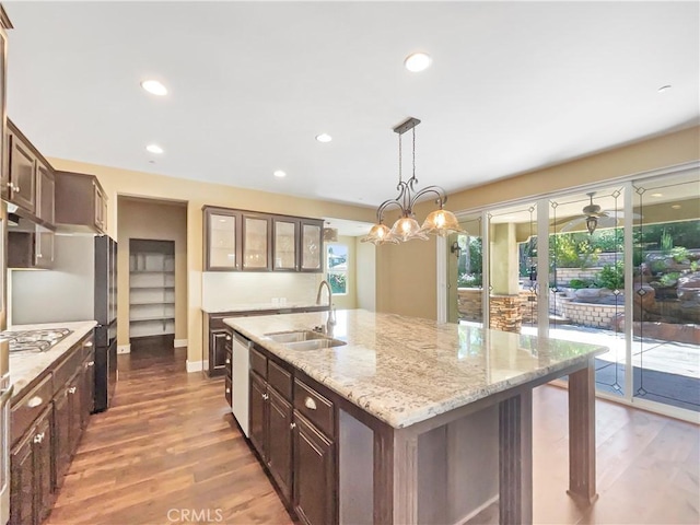 25329 Wild View Rd, Menifee, CA 92584 - kitchen featuring a sink, a kitchen island with sink, wood finished floors, glass insert cabinets, and recessed lighting