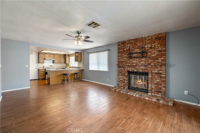 1819 Acosta Ave, Lancaster, CA 93535 - living area with baseboards, ceiling fan, dark wood-style flooring, and a brick fireplace