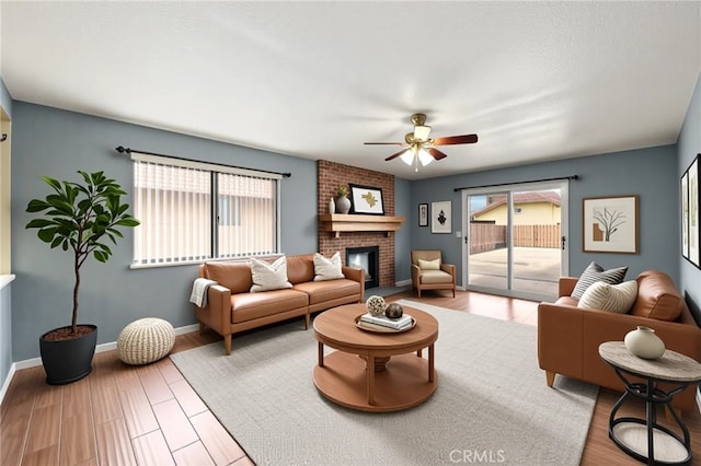 1819 Acosta Ave, Lancaster, CA 93535 - living area with ceiling fan, a brick fireplace, baseboards, and wood finished floors