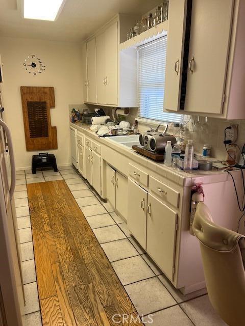 38833 Sage Tree St, Palmdale, CA 93551 - kitchen with tile countertops, white cabinets, light tile patterned floors, and backsplash