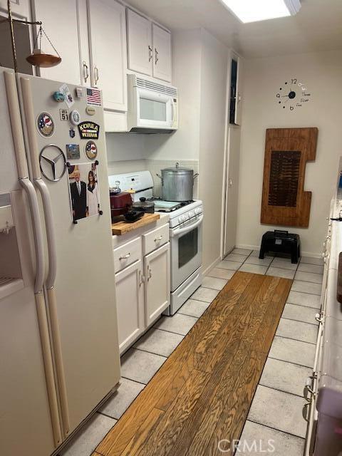 38833 Sage Tree St, Palmdale, CA 93551 - kitchen with white appliances, light tile patterned flooring, light countertops, and white cabinets