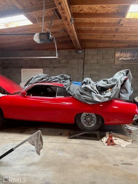 38833 Sage Tree St, Palmdale, CA 93551 - garage featuring concrete block wall and a garage door opener