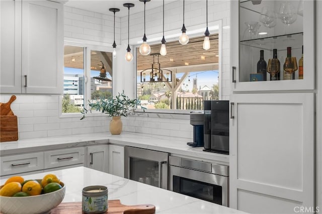 4674 Norton Pl, Riverside, CA 92506 - kitchen featuring beverage cooler, backsplash, white cabinets, and plenty of natural light