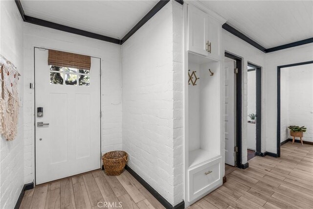 4674 Norton Pl, Riverside, CA 92506 - mudroom featuring light wood-style floors, crown molding, and brick wall