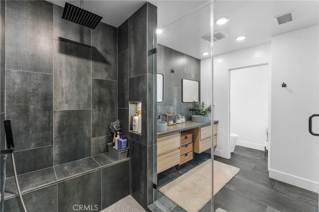 4674 Norton Pl, Riverside, CA 92506 - bathroom featuring double vanity, toilet, a tile shower, baseboards, and recessed lighting