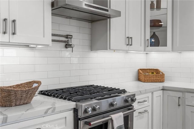 4674 Norton Pl, Riverside, CA 92506 - kitchen with gas stove, wall chimney exhaust hood, white cabinets, glass insert cabinets, and decorative backsplash