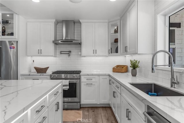 4674 Norton Pl, Riverside, CA 92506 - kitchen with appliances with stainless steel finishes, wall chimney exhaust hood, a sink, white cabinets, and backsplash