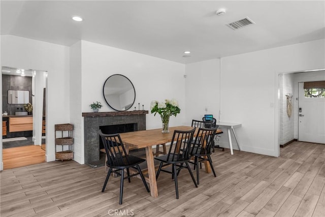 4674 Norton Pl, Riverside, CA 92506 - dining space featuring light wood-style flooring, a fireplace, baseboards, and recessed lighting