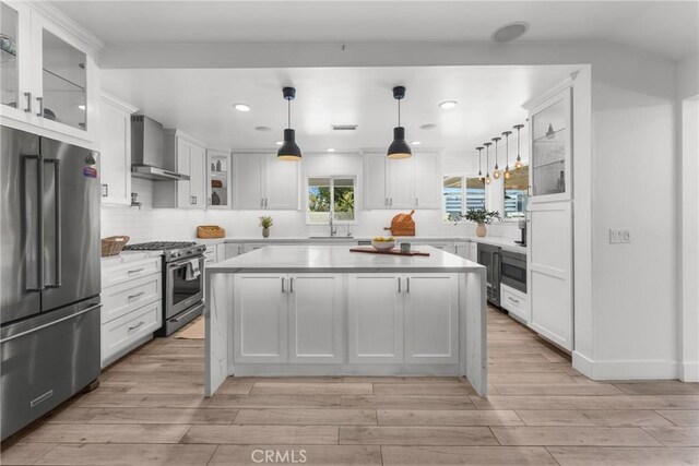 4674 Norton Pl, Riverside, CA 92506 - kitchen with high end appliances, wall chimney range hood, light countertops, recessed lighting, and a kitchen island
