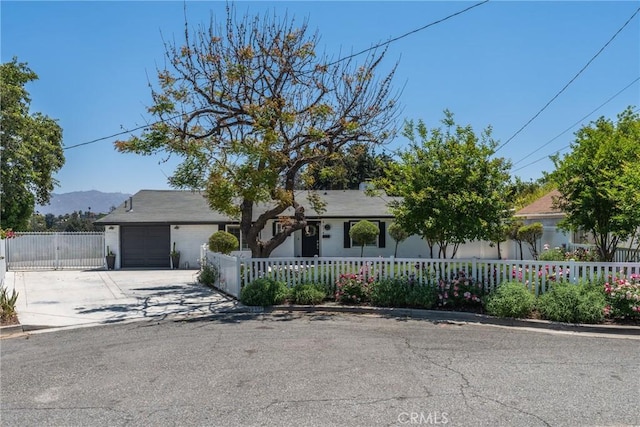 4674 Norton Pl, Riverside, CA 92506 - view of front of home with a fenced front yard, a garage, concrete driveway, and a mountain view