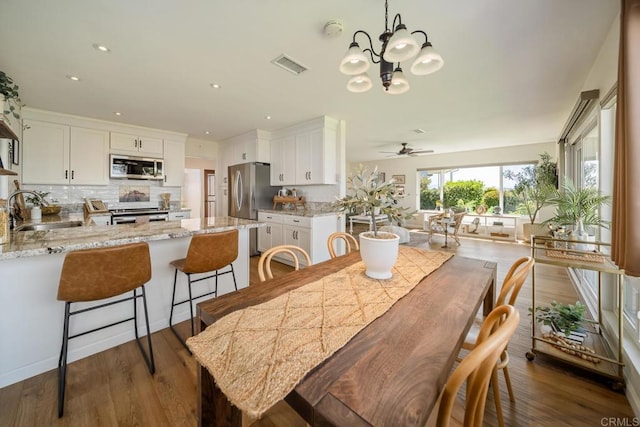 3890 Vista Campana S Unit 35, Oceanside, CA 92057 - dining area with a chandelier, ceiling fan, dark wood finished floors, and recessed lighting